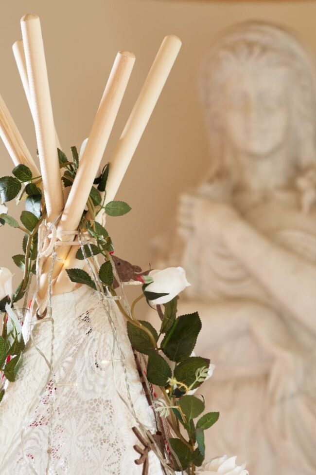 Tipi frame hire with flowers and trailing foliage around the top