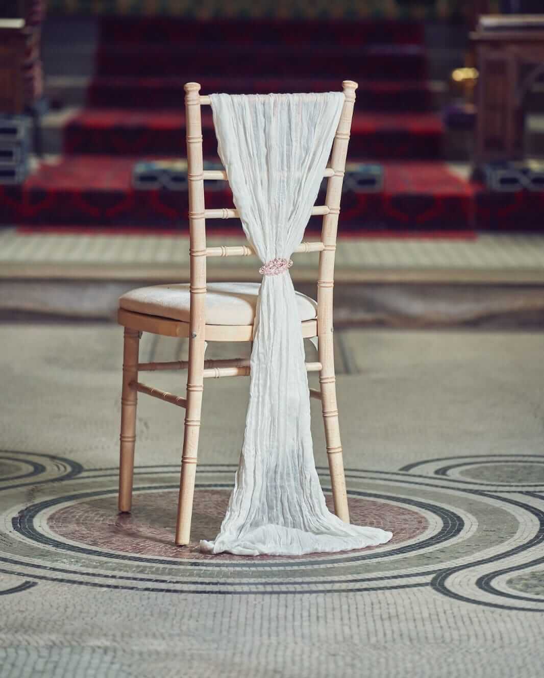 Cheesecloth chair drape with a soft textured vertical fall