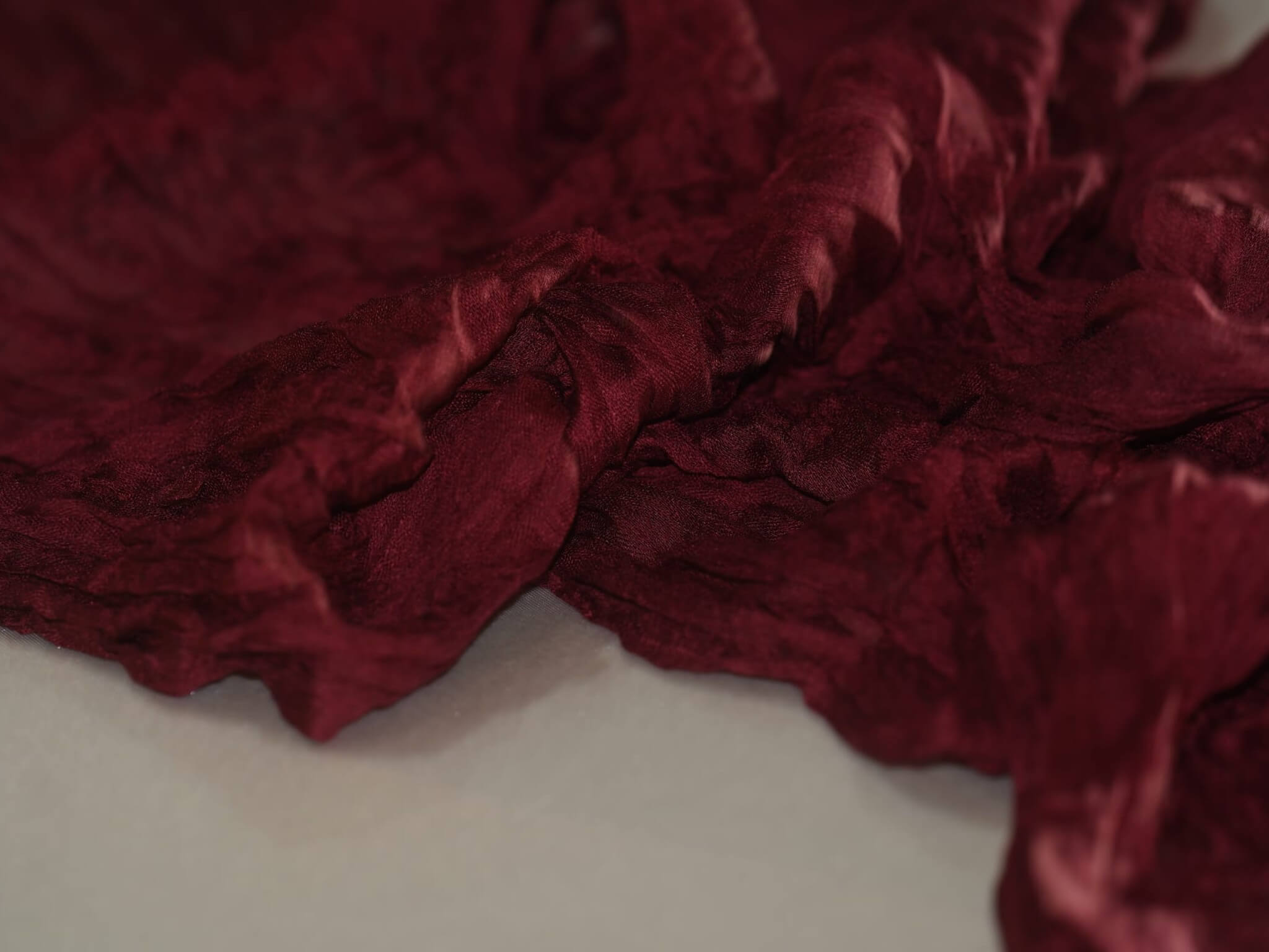 Gathered burgundy cheesecloth runner fabric styled on a dressed table