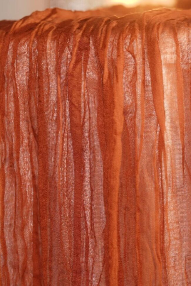 Terracotta table runner in cheesecloth fabric with soft drape detail