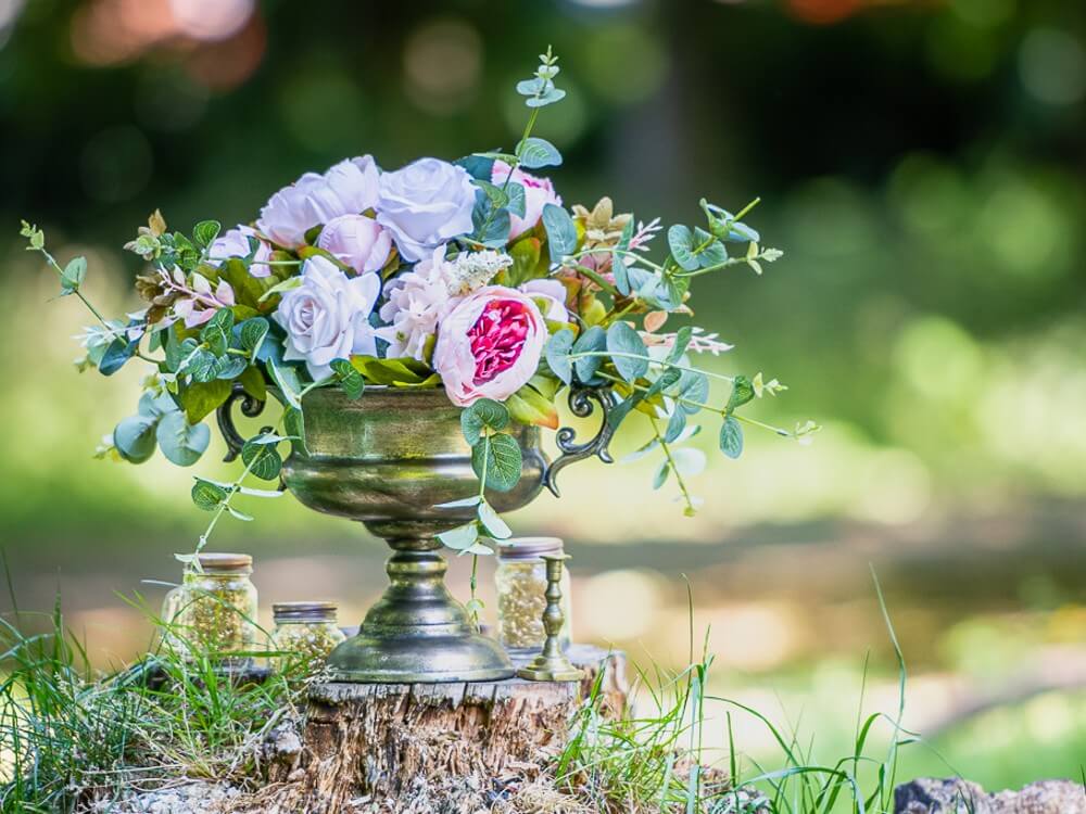 Flower bowls displayed outdoors with mixed artificial roses and greenery.