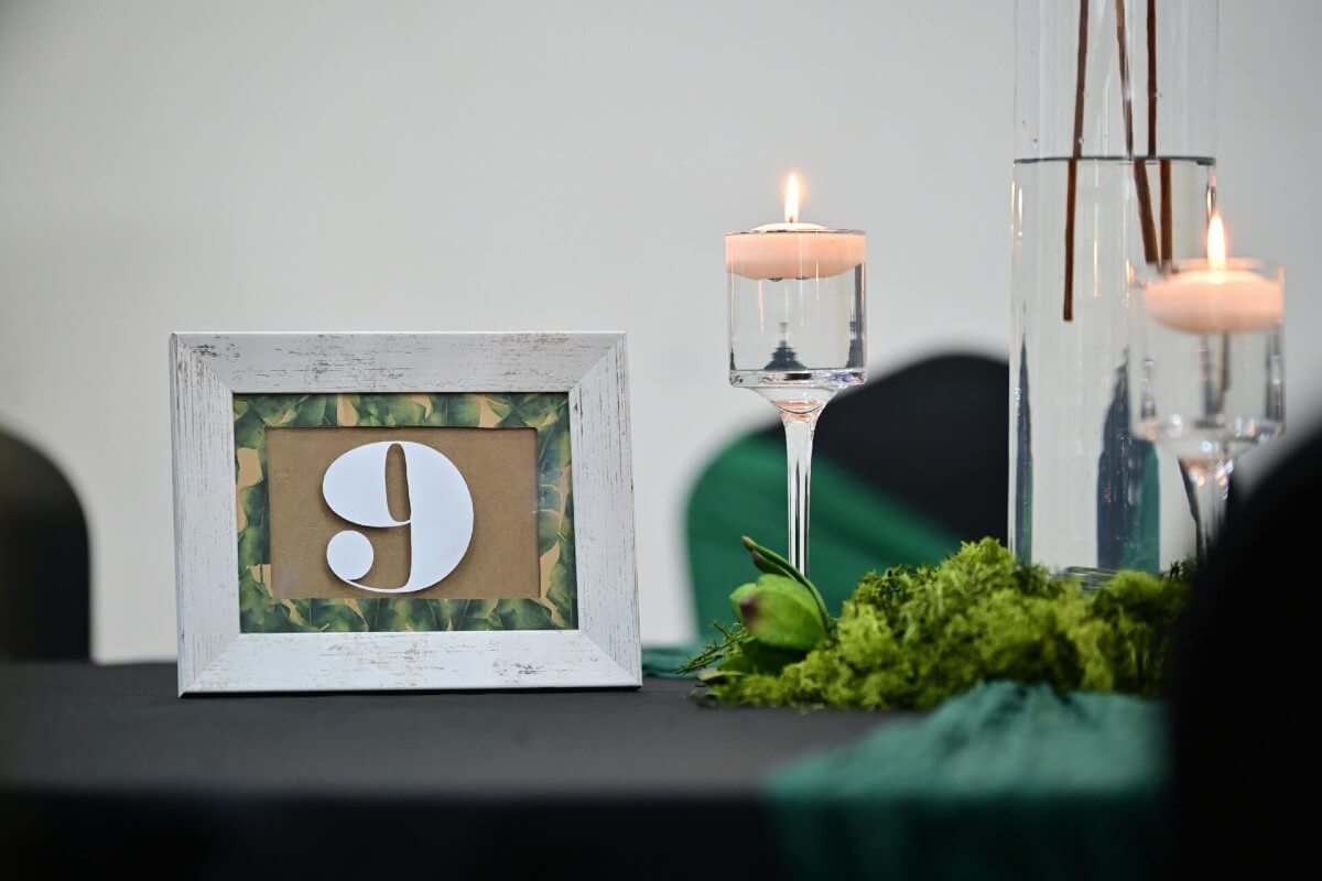 Table numbers displayed with floating candles and greenery for event décor.