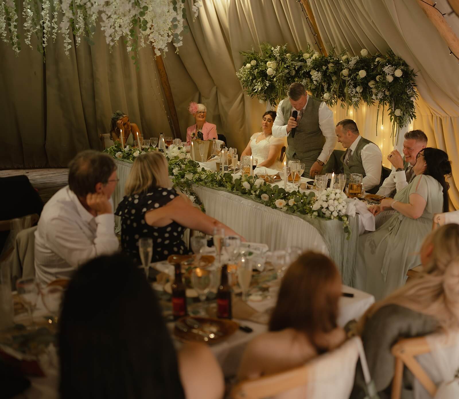 Personalised wedding backdrop with drapes and hanging flowers