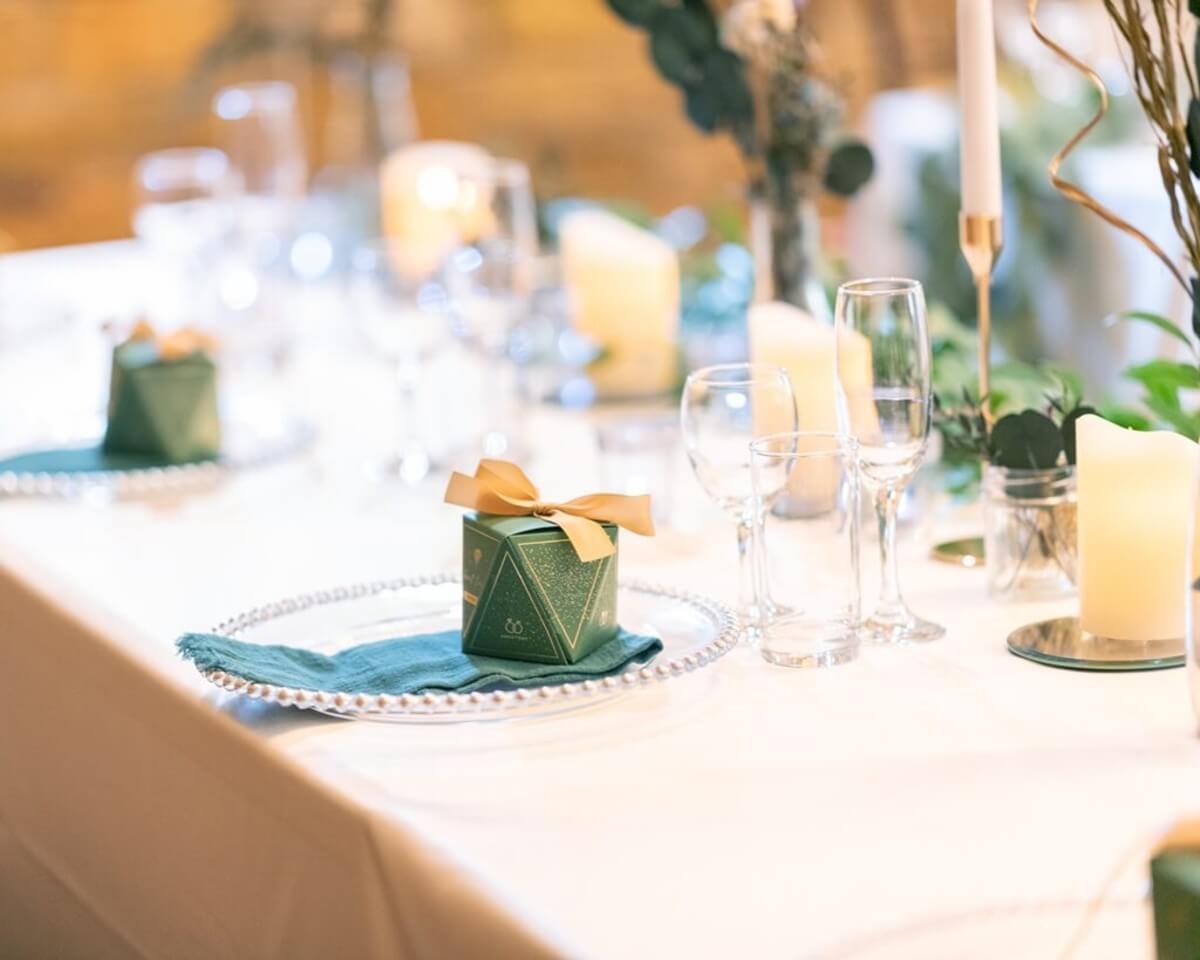 Elegant wedding table setting with glassware, candles and favour boxes, styled for wedding hire decor.