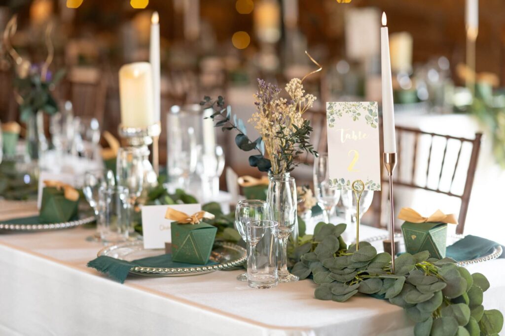 Elegant wedding table styled by wedding decorators with candles, greenery, gold accents and personalised table settings.