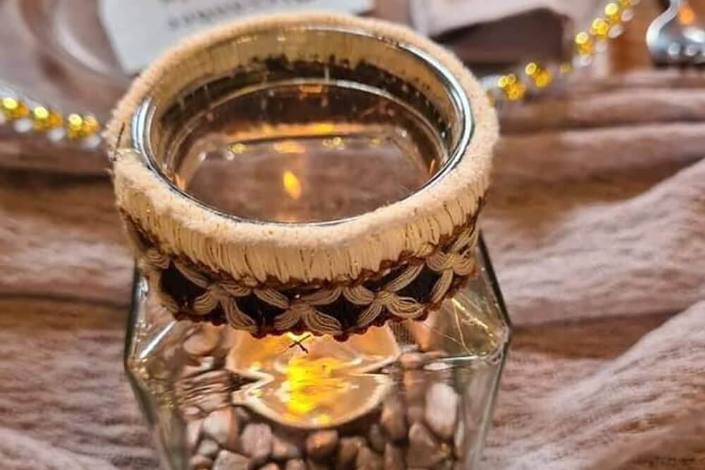 Decor hire extras glass holder for candles with rustic trim.