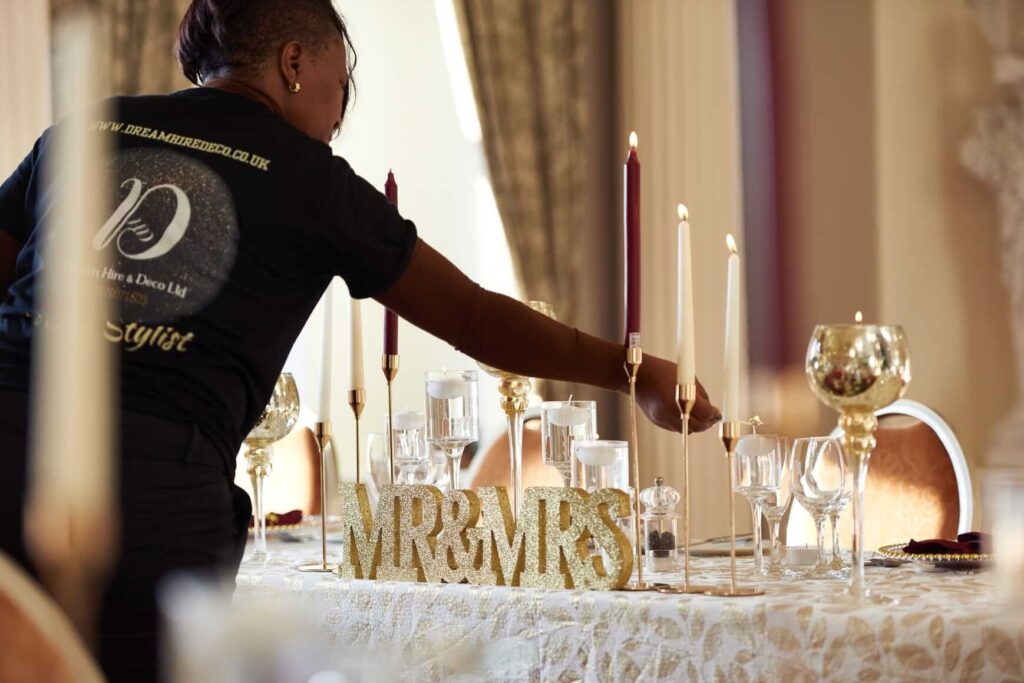 Professional styling of a wedding table with candles, glassware and gold décor by a venue stylist.