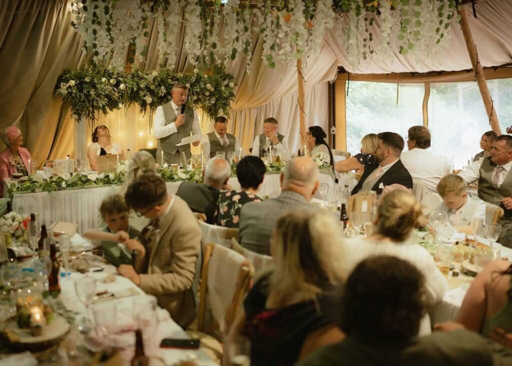 Wedding reception speeches inside a woodland venue tipi.
