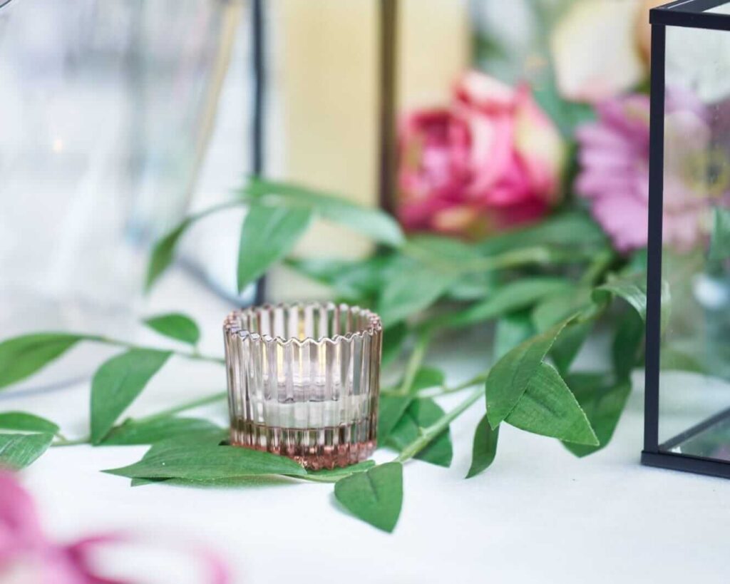 Rustic wedding lighting with ribbed glass votive on greenery