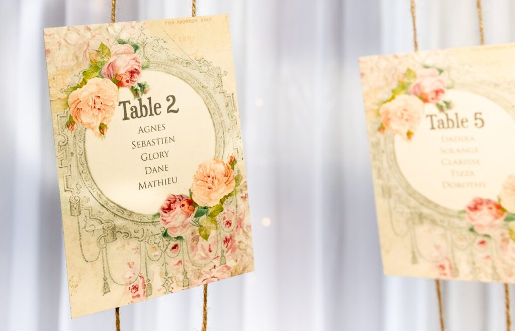 Floral wedding table plan cards on twine for a seating display, ideal for wedding table plan hire.