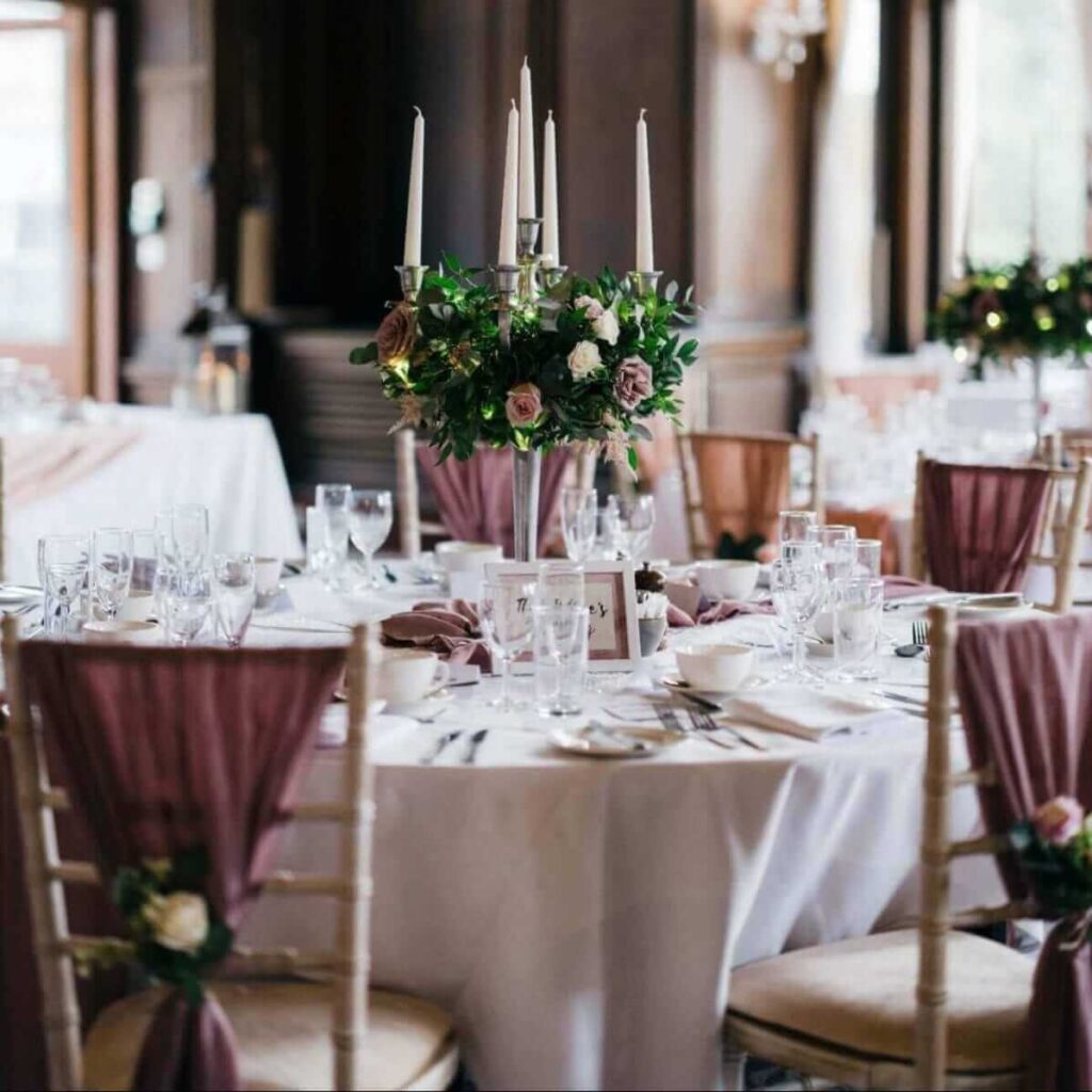 Chair decorations for party tables with mauve chair drapes and floral accents