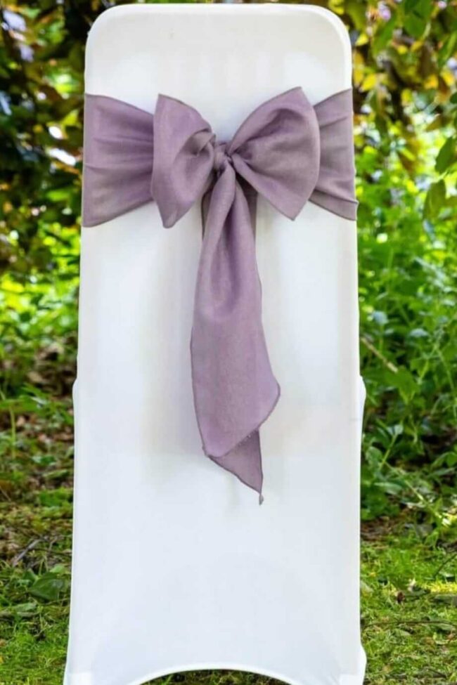 White chair covers styled on venue chairs for a clean event seating setup