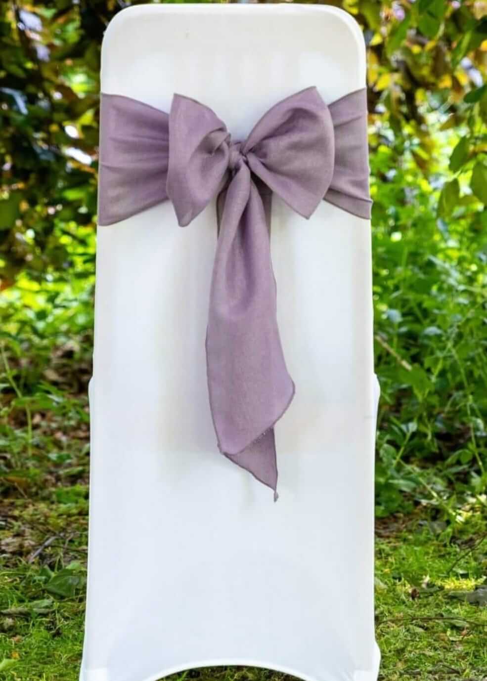 White chair covers styled on venue chairs for a clean event seating setup