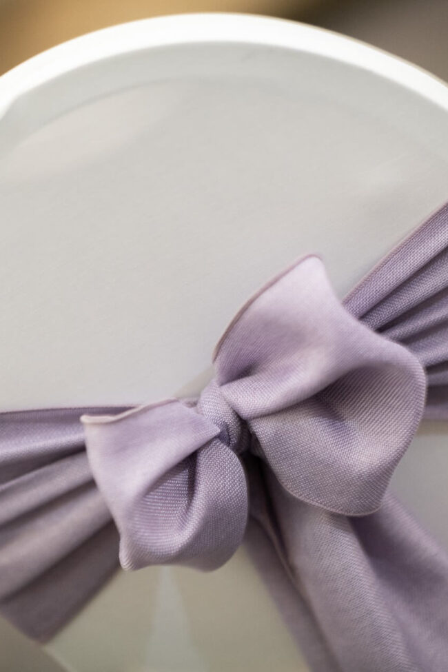 Lilac sashes close-up tied in a bow on a white chair cover