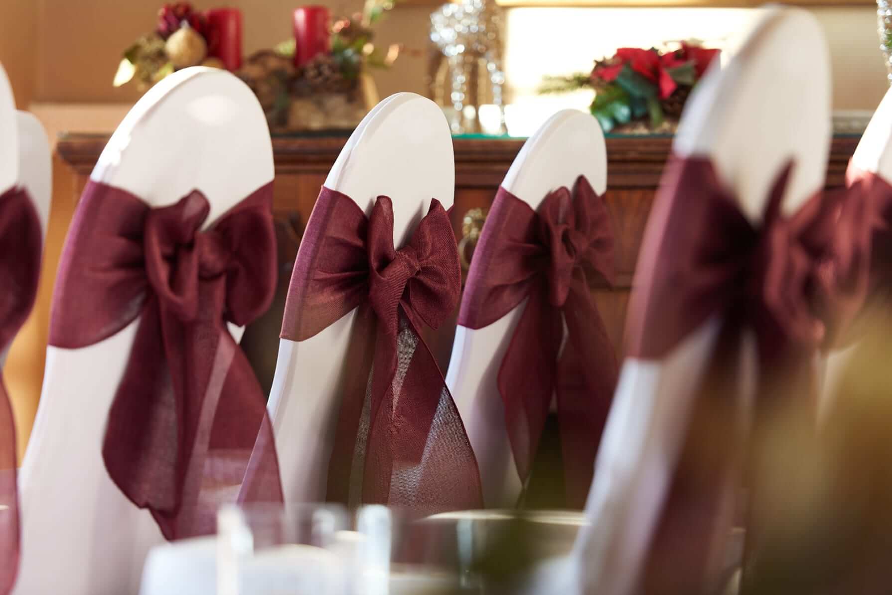Red chair sashes close-up showing a tidy bow on a white chair cover