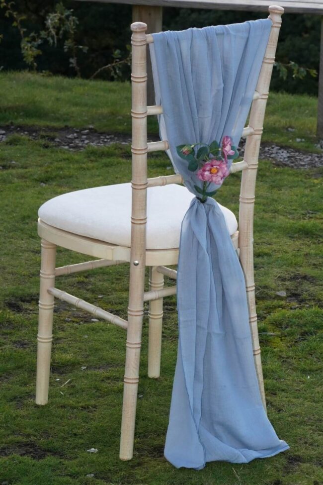 Dusty blue cheesecloth chair drape styled as a vertical drop on a chiavari chair