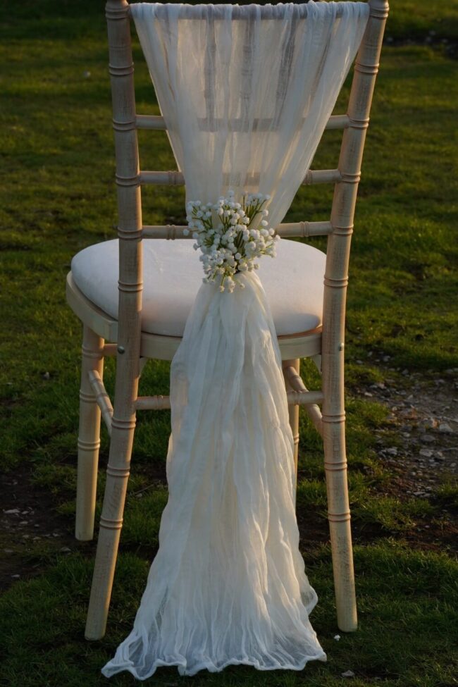 White cheesecloth drape with a soft drop on the back of a chiavari chair
