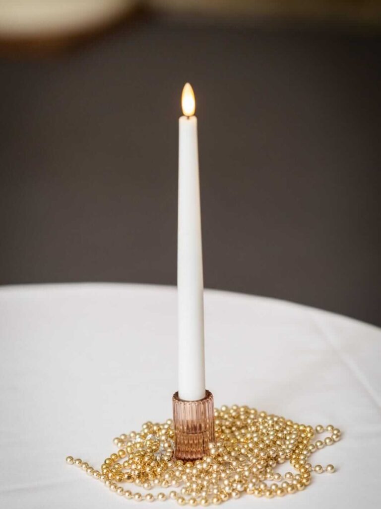 Small candle holder in rose-gold glass with white taper candle