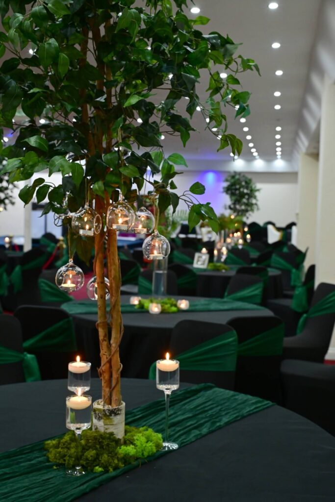 Tree centrepiece with hanging glass tealights on green table runner