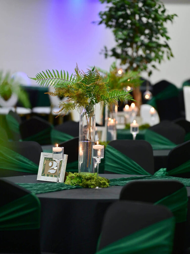 green table runner with tall vase centrepiece and candlelight