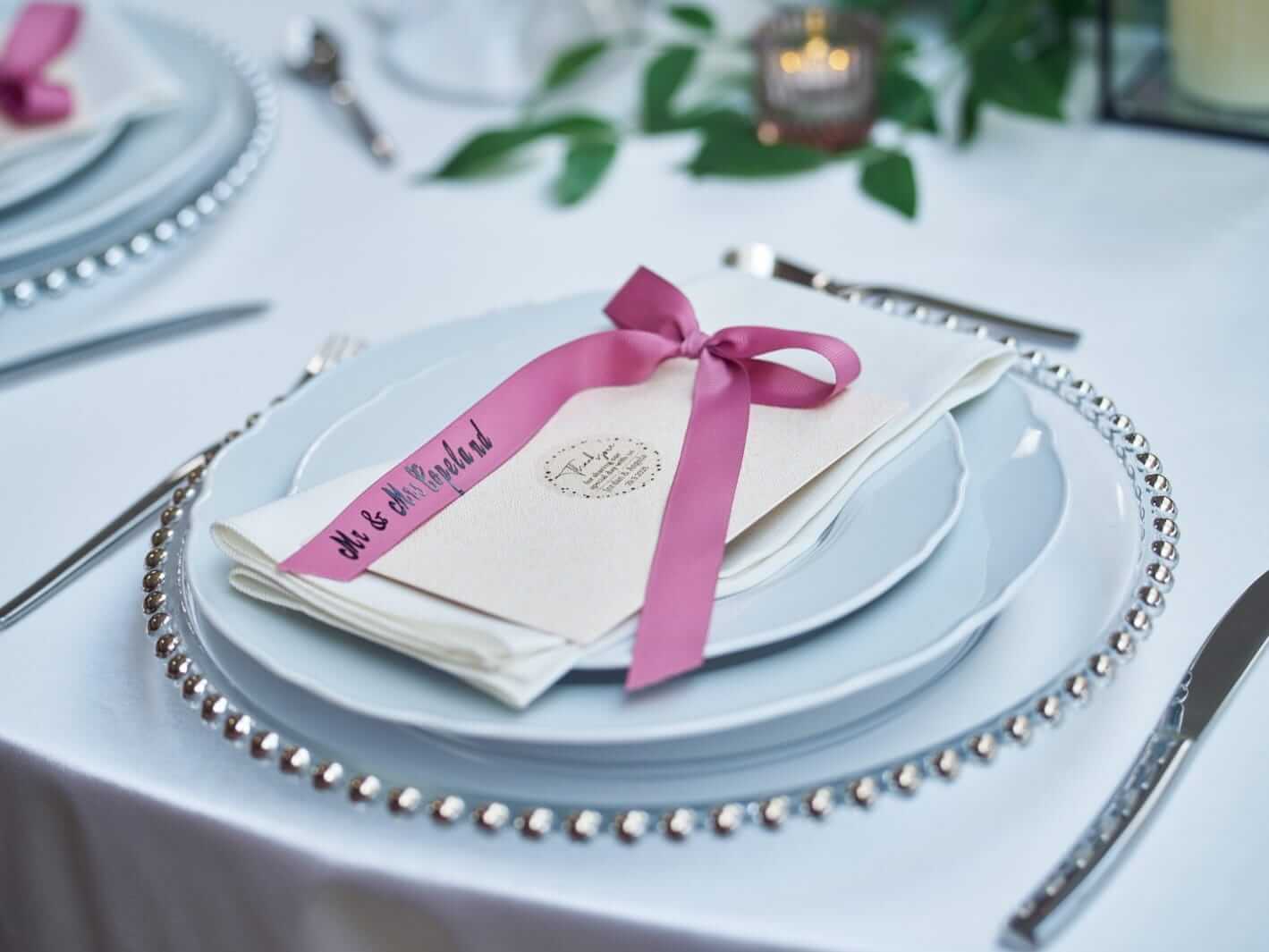 Place cards for wedding styled as personalised ribbon names on a table setting