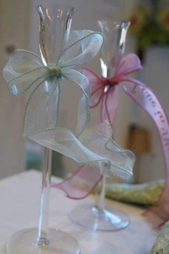Table place names styled on soft ribbon bows around wedding glassware