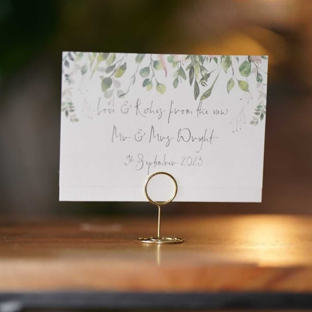 Placecards for wedding displayed in a gold name card holder for guest table styling