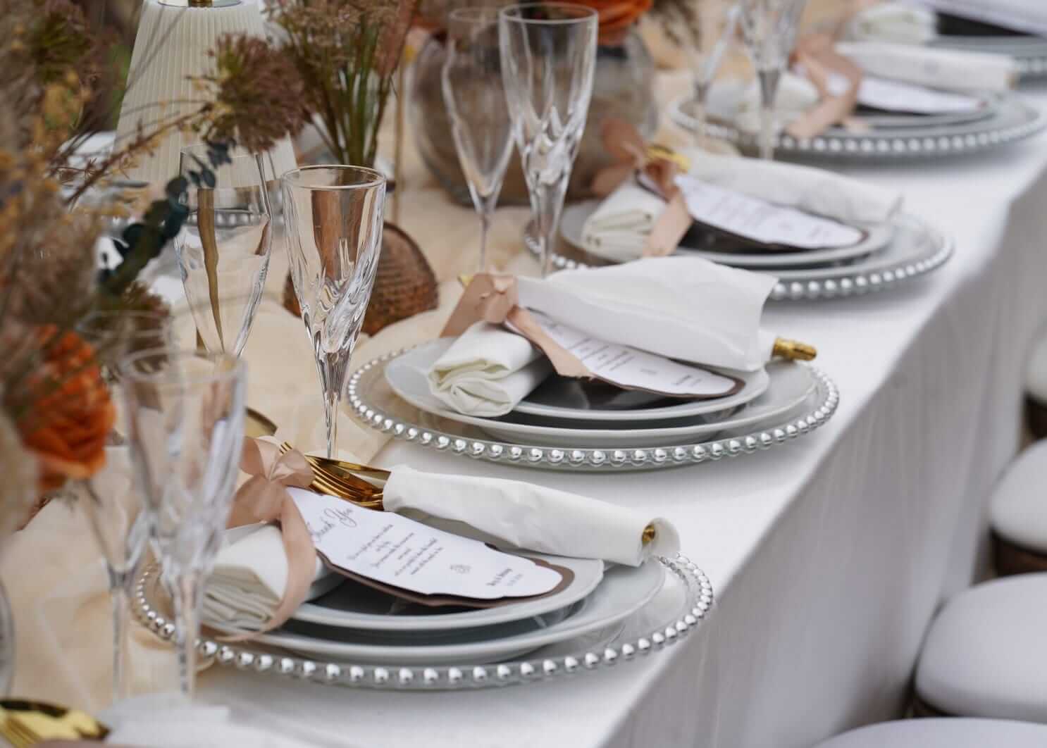 Custom stationery cards styled with napkins, charger plates and gold cutlery on a wedding table