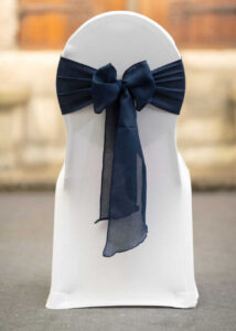 Chair back decoration with a dark fabric sash bow