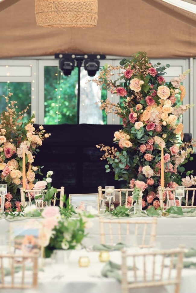 Broken floral arch hire with two staggered pillars of pink and white flowers