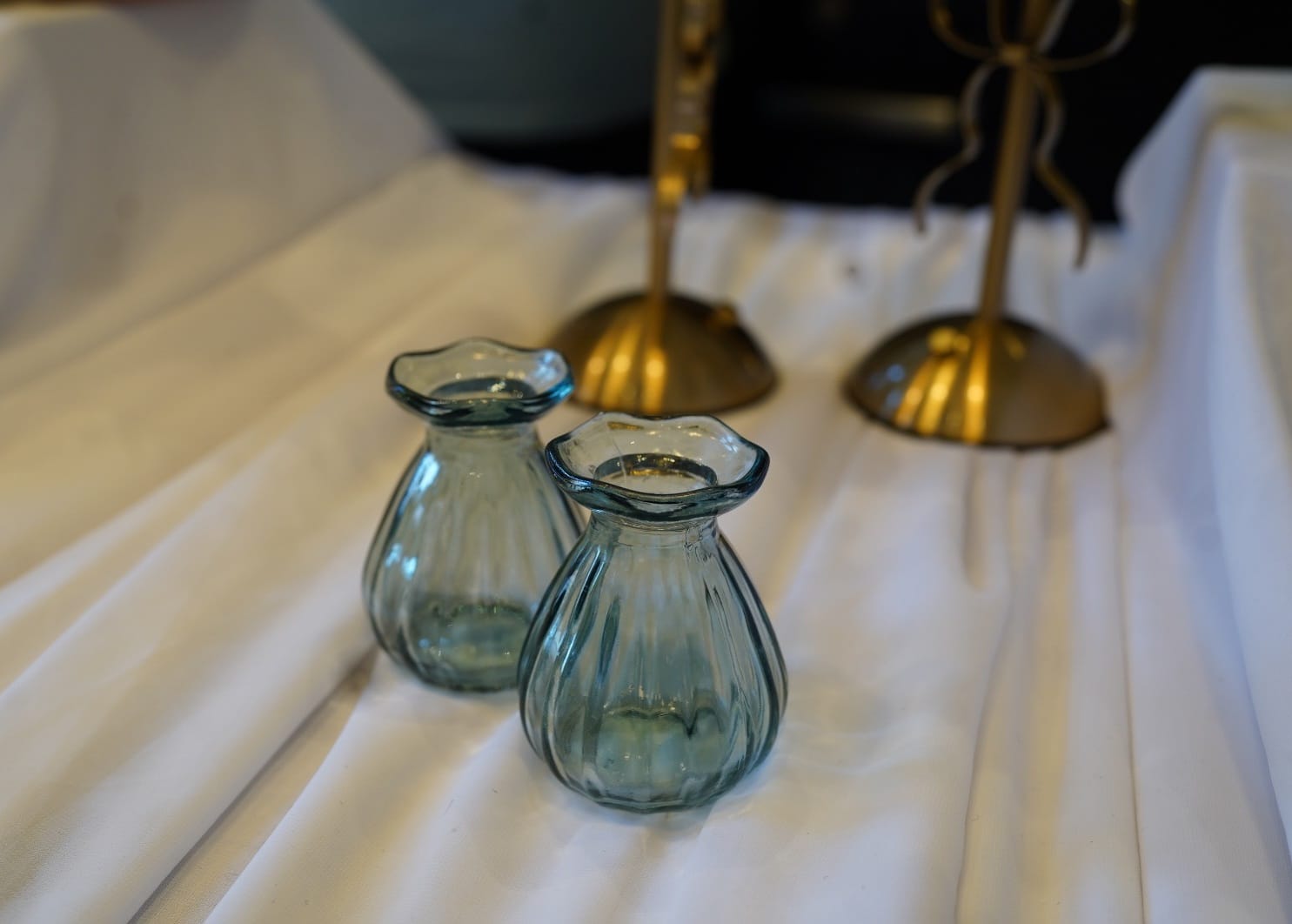 Blue ribbed bud vases with scalloped rims on a table